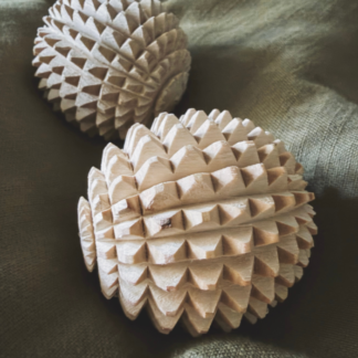 Two wooden acupressure labour balls on soft fabric surface
